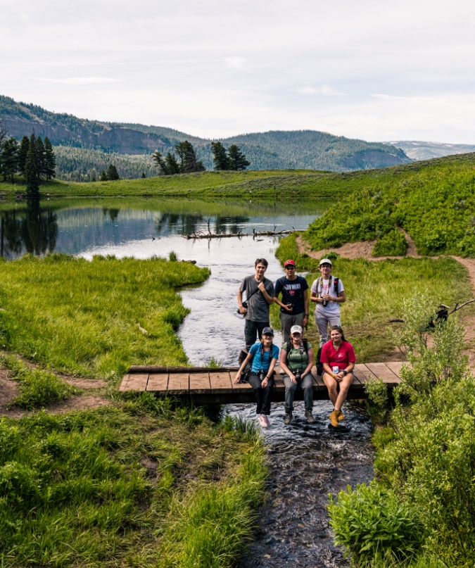 nat-geo-student-group-smiling-on-yellowstone-bridge-over-river