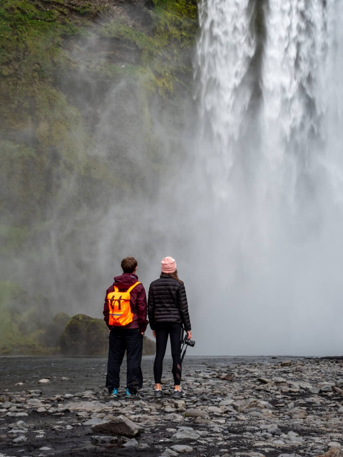 two-students-beneath-waterfall-iceland